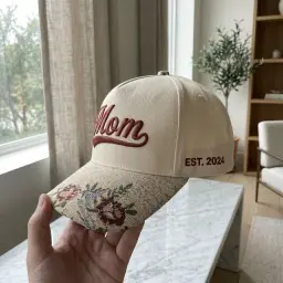 Cream cap with floral tapestry brim and embroidered text